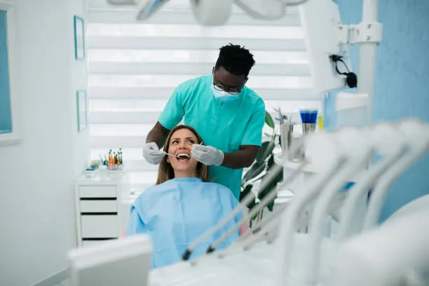 Paciente en el sillón mientras el odontólogo revisa su dentadura